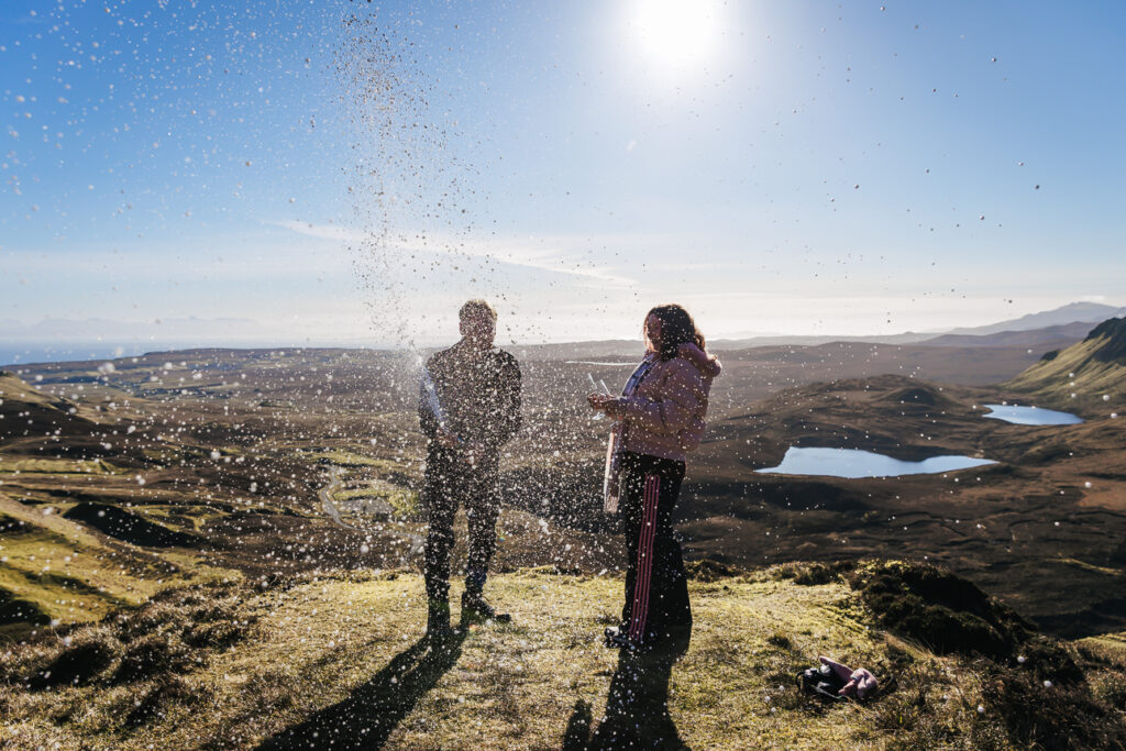 a spray of champagne after Planning a Proposal on the Isle of Skye